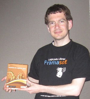 Karl Fogel holding a paperback copy of 'Produire Logiciels Libres'.